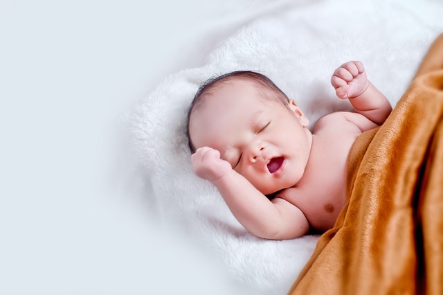 Photo by kelvin octa : https://www.pexels.com/photo/baby-lying-on-white-fur-with-brown-blanket-1973270/